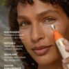 Nærbillede af en person, der påfører Soleil Toujours Mineral Ally Eye Glow + Illuminator SPF 30 ml nær deres højre øje med en metallisk applikator. Teksten til venstre beskriver ingredienser: niacinamid, peptider, squalane og natriumhyaluronat.