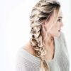 Sideprofil af en kvinde med en løs fiskehalefletning i sit blonde hår, perfekt stylet med Innersense I Create Finish - Shine Spray 295ml. Hun er iført en lysegrå, off-the-shoulder strikket sweater. Baggrunden er almindelig hvid.