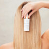 En kvinde reder sit hår med Innersense Hair Renew Daily Active Serum 29 ml.