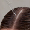 En kvindes hår bliver sprayet med Innersense Hair Renew Daily Active Serum 29 ml.