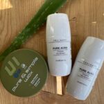et par flasker lotion, der sidder på toppen af et træbord.