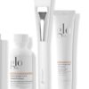 Three Glo Skin Beauty Radiant Spa Day Kit - Begrænsede hudplejeprodukter: en hvid flaske Hydra-Bright Pro 5 Liquid Exfoliant, en hvid tube Hydra-Bright AHA Glow Mask og en hvid påføringsbørste.