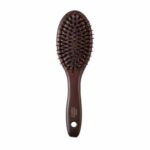 John Masters Organics Combo Paddle Brush - Mini er en brun hårbørste med et ovalt hoved og børstehår, med et hul i håndtaget til ophængning.